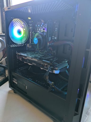 A black computer tower with RGB lighting and visible internal components.