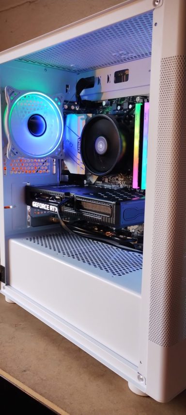 A white PC case showcasing internal components and colourful RGB lighting.