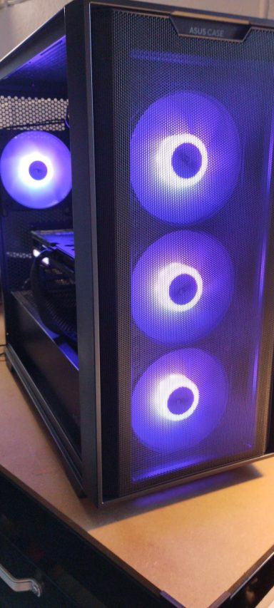 A sleek computer case with three illuminated fans in blue and purple hues.