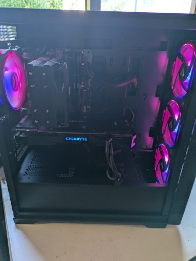 A gaming PC with RGB lighting and a glass side panel showcasing internal components.