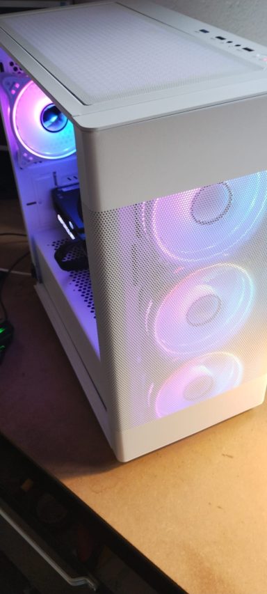 A white computer case with RGB fans illuminating the interior.